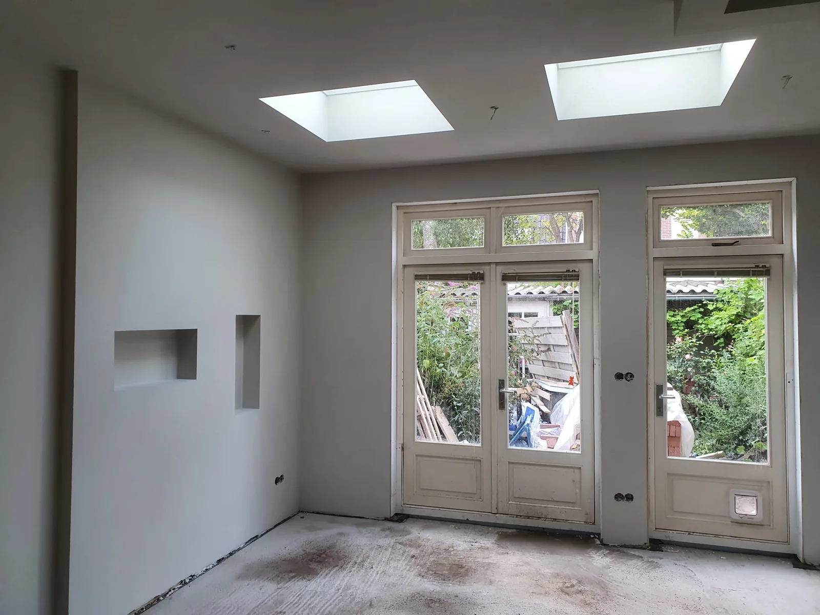 Lichte wanden en plafond rond twee daklichten en tuindeuren